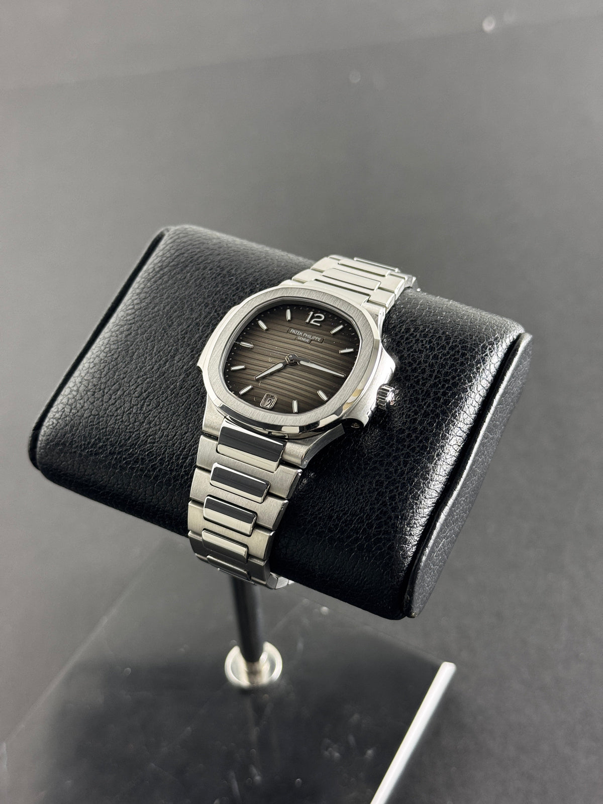 Patek Philippe Nautilus 7118/1A in steel with a grey gradient dial on a steel bracelet, resting on a leather display stand