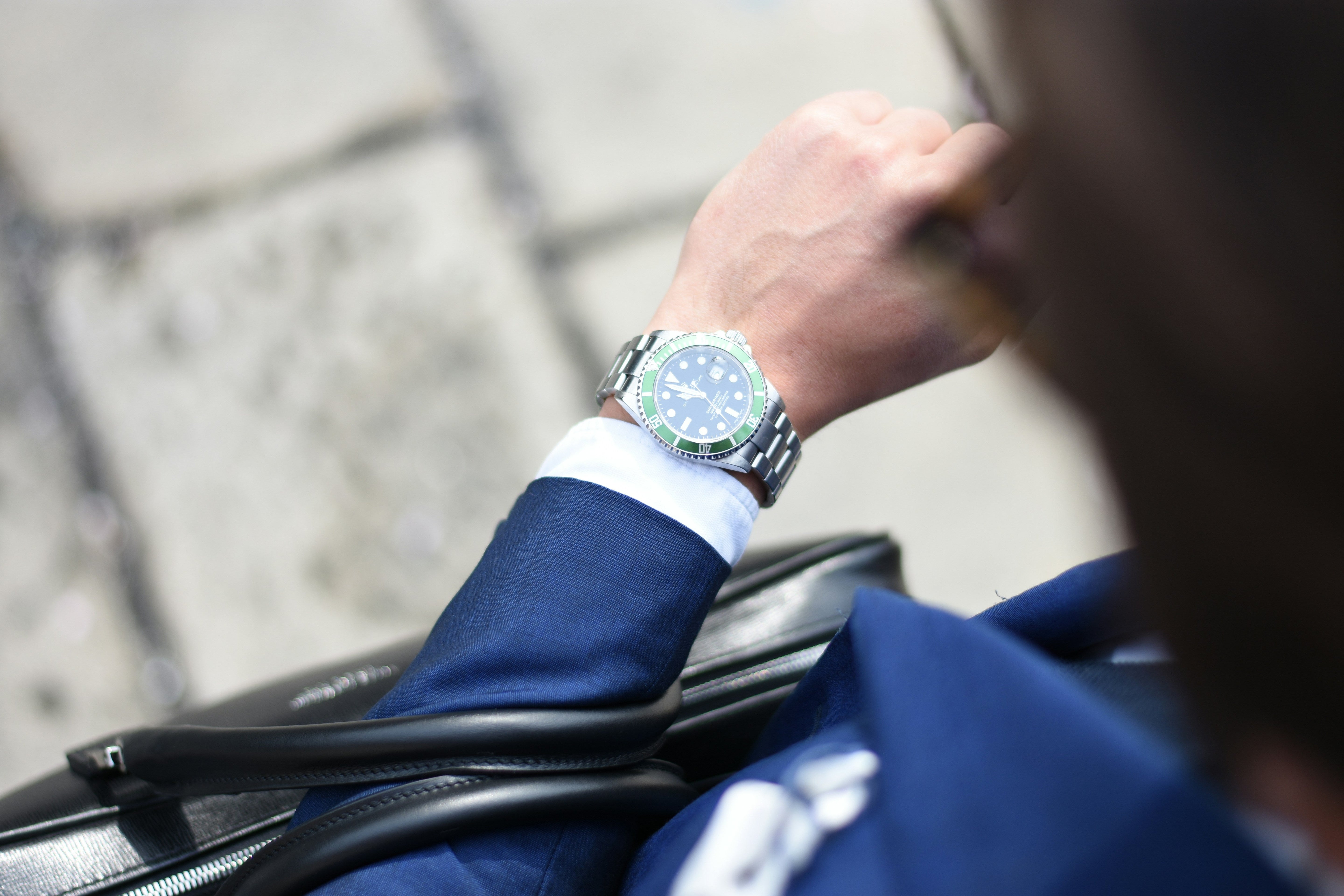 Businessman consulting a dive watch on his wrist, showcasing the world offered by a luxury watch broker.