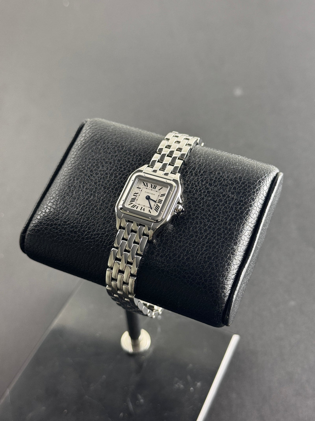 Cartier Panthère Small quartz in steel with a white Roman numeral dial, on a black leather cushion