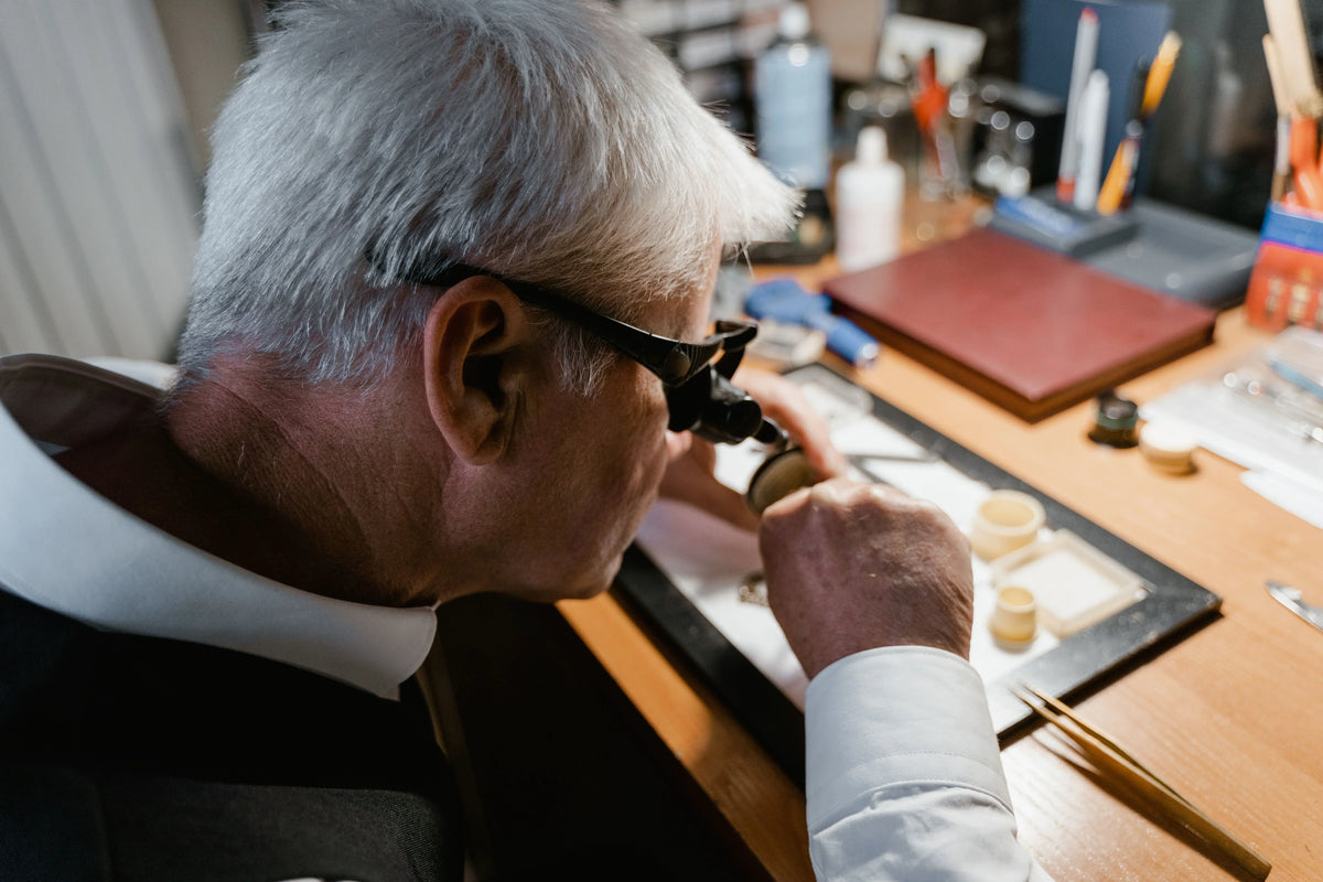 Watchmaker performing a Rolex authentication in Montreal under a microscope to verify a watch's movement