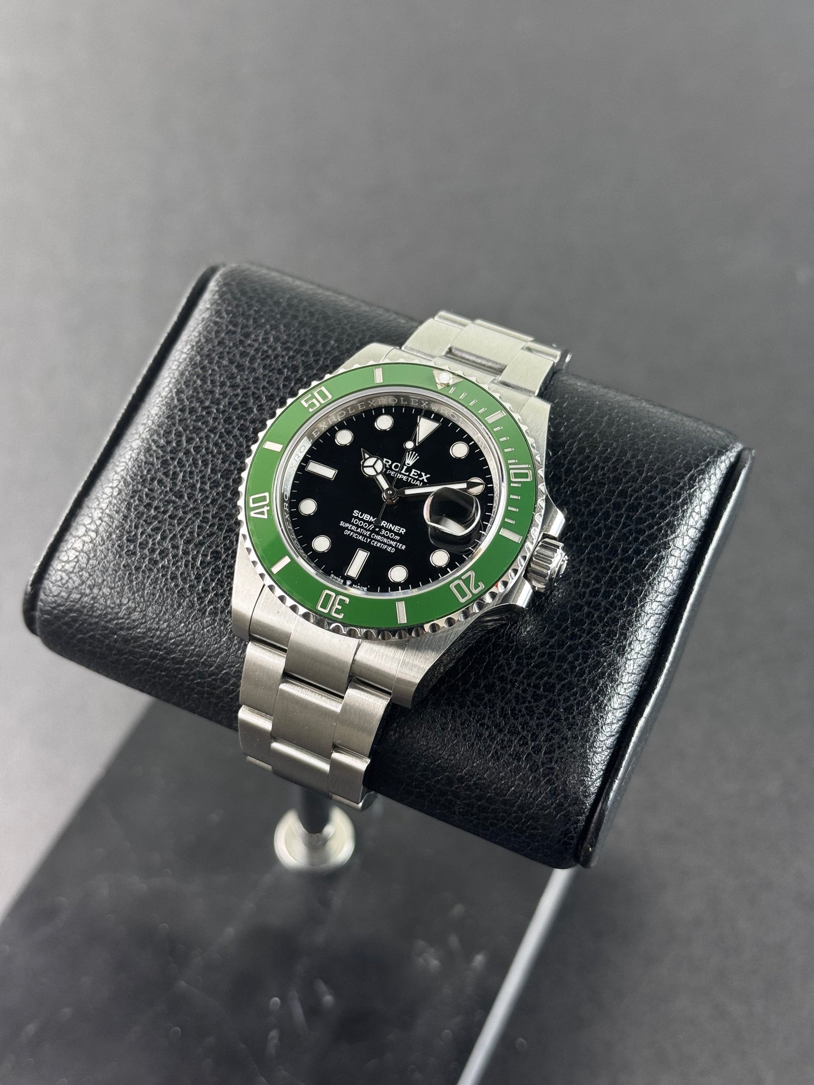 Rolex Submariner à cadran noir et lunette en céramique sur fond sombre, montre de plongée emblématique