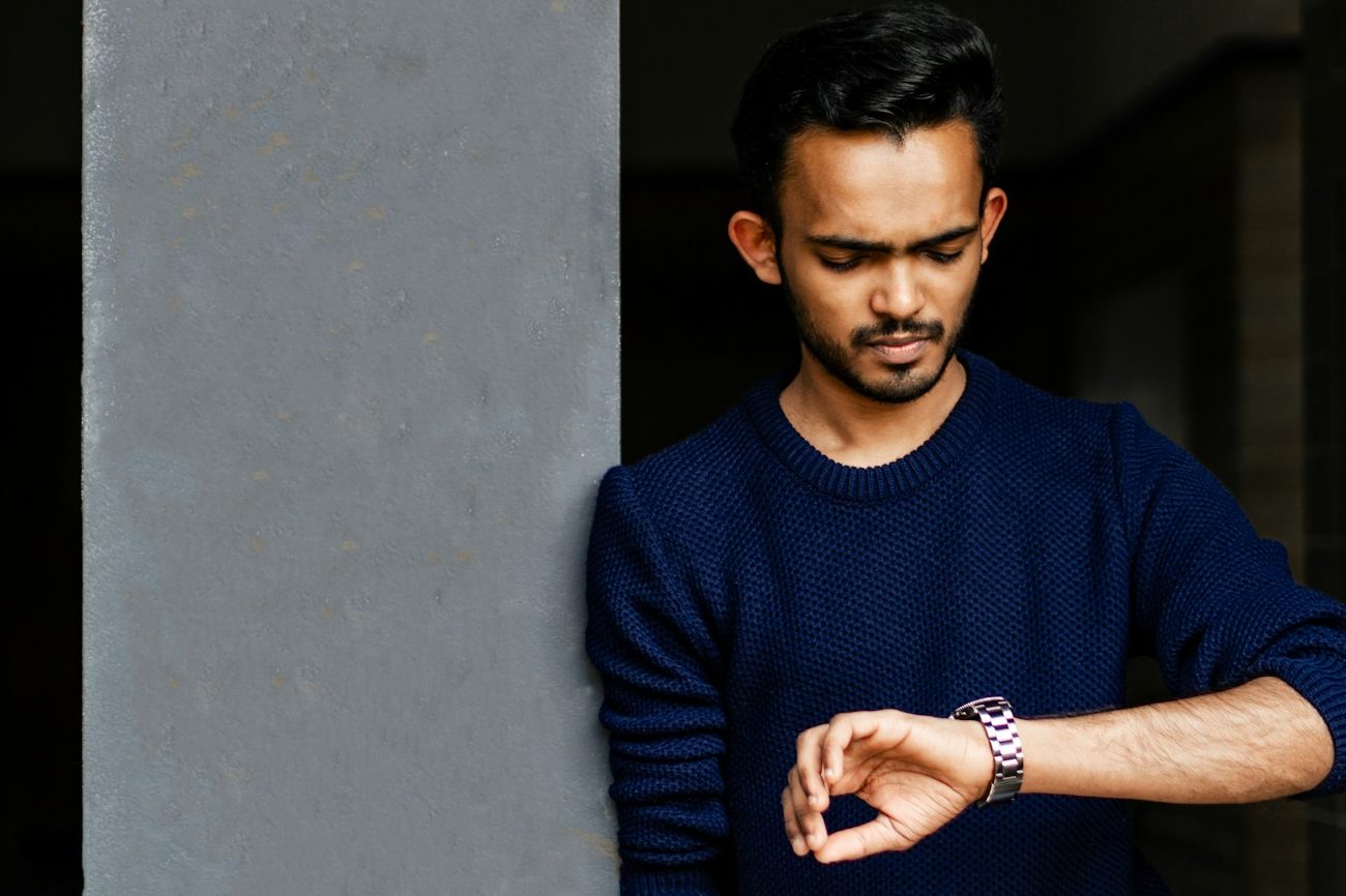 Homme consultant la montre-bracelet en acier à son poignet